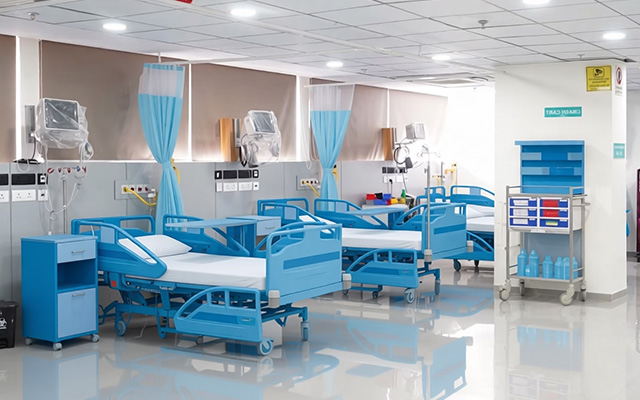 Clean and modern hospital ward with multiple patient beds, monitoring equipment, and organized medical care infrastructure.